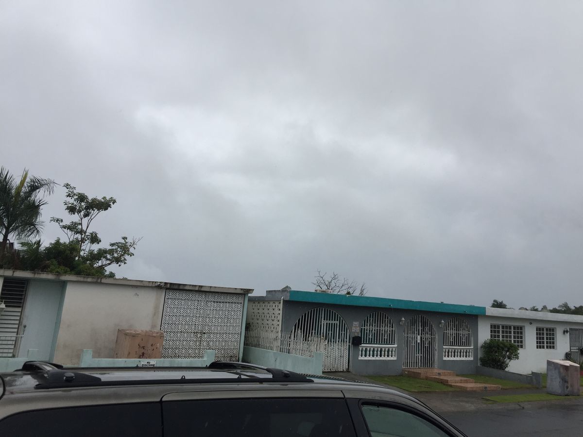 An overcast tropical rain shower over a residential street in Carolina, Puerto Rico